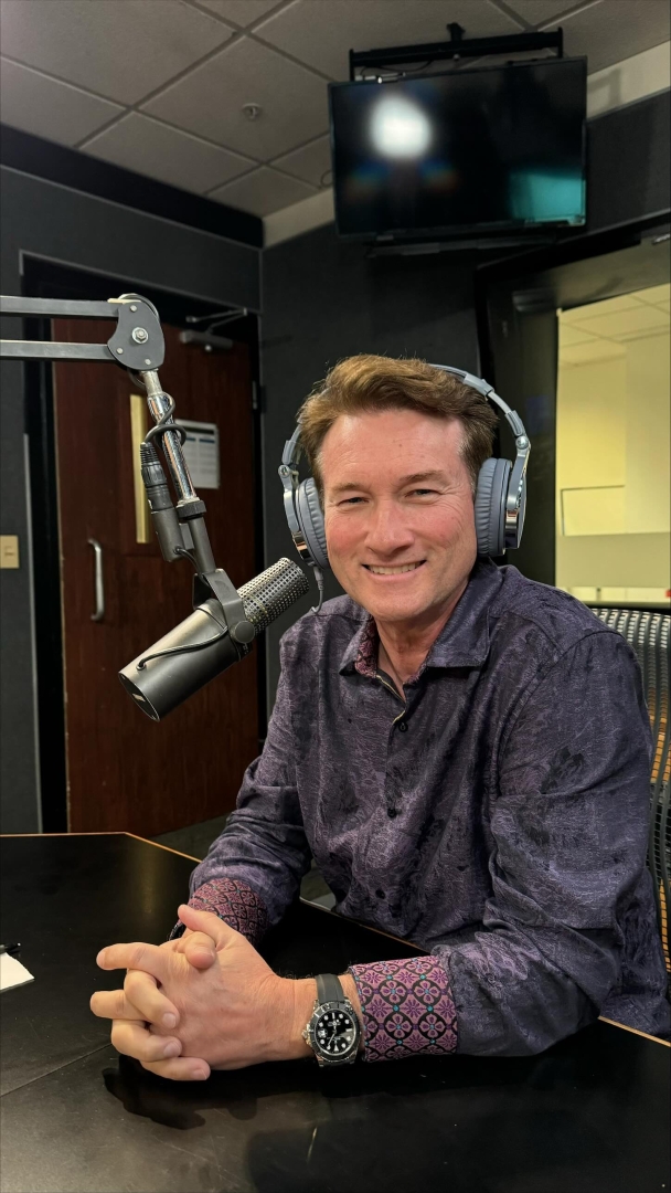 Dr. McNeel wearing headphones, speaking on a radio show